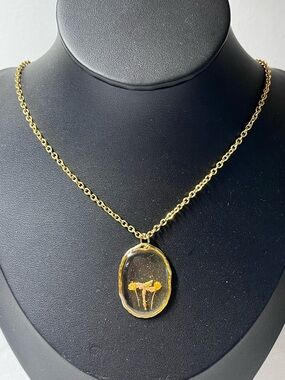 Gold-toned chain necklace 
Oval resin pendant 
dried flowers